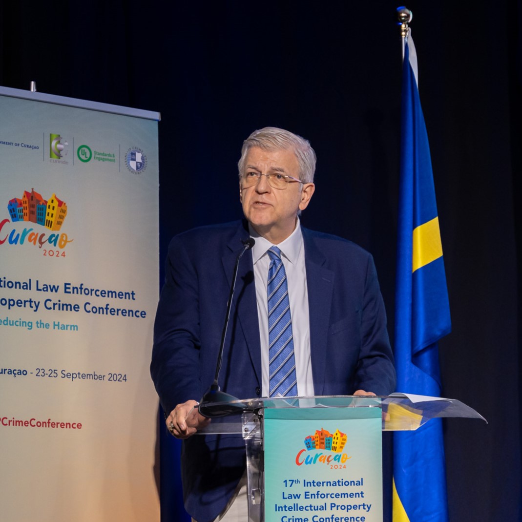 Tim Rivelli standing at a podium and speaking at the 2024 International Law Enforcement Intellectual Property Crime Conference in Willemstad, Curaçao