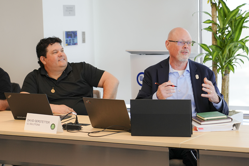 Two male colleagues speaking in meeting.