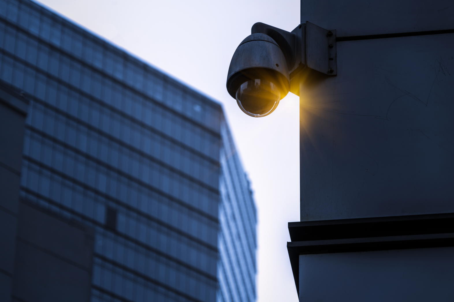 A security camera posted on the side of a building