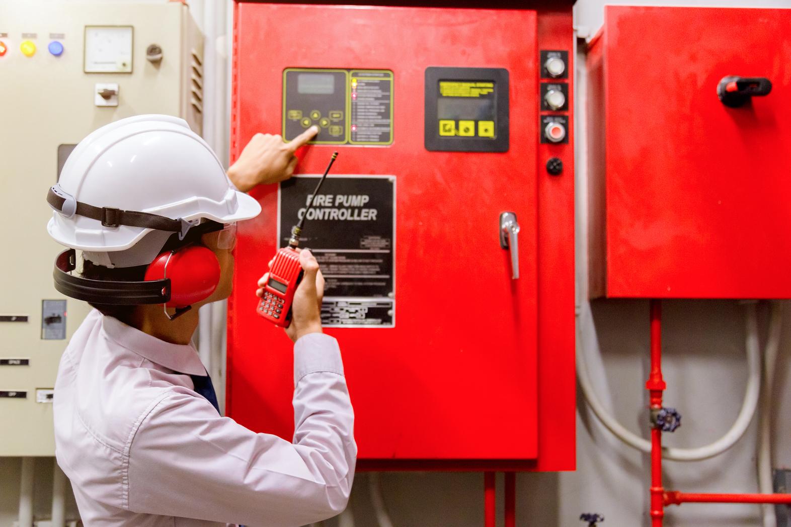 Person adjusting fire pump control panel