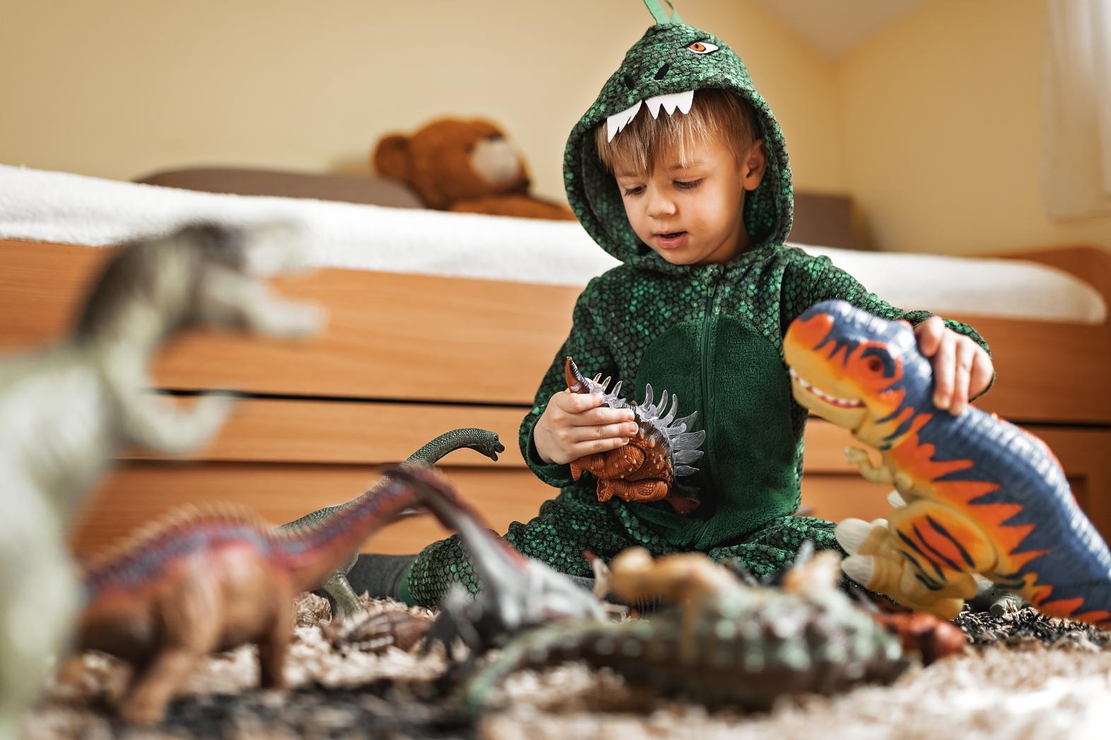 toddler playing with dinosaur toys