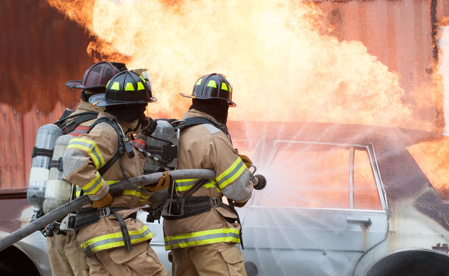 Firefighters attacking a fire with a fire hose