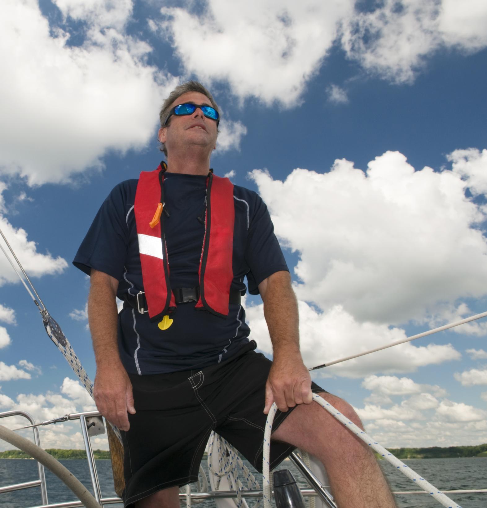 Man on a boat wearing an inflatable life jacket 