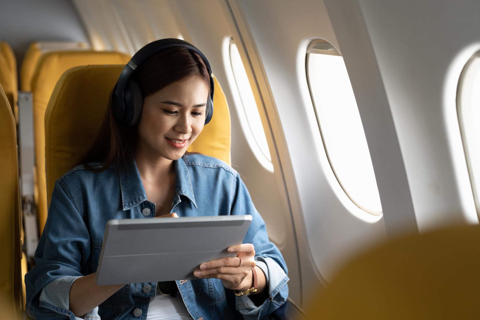 Woman on flight working on digital tablet