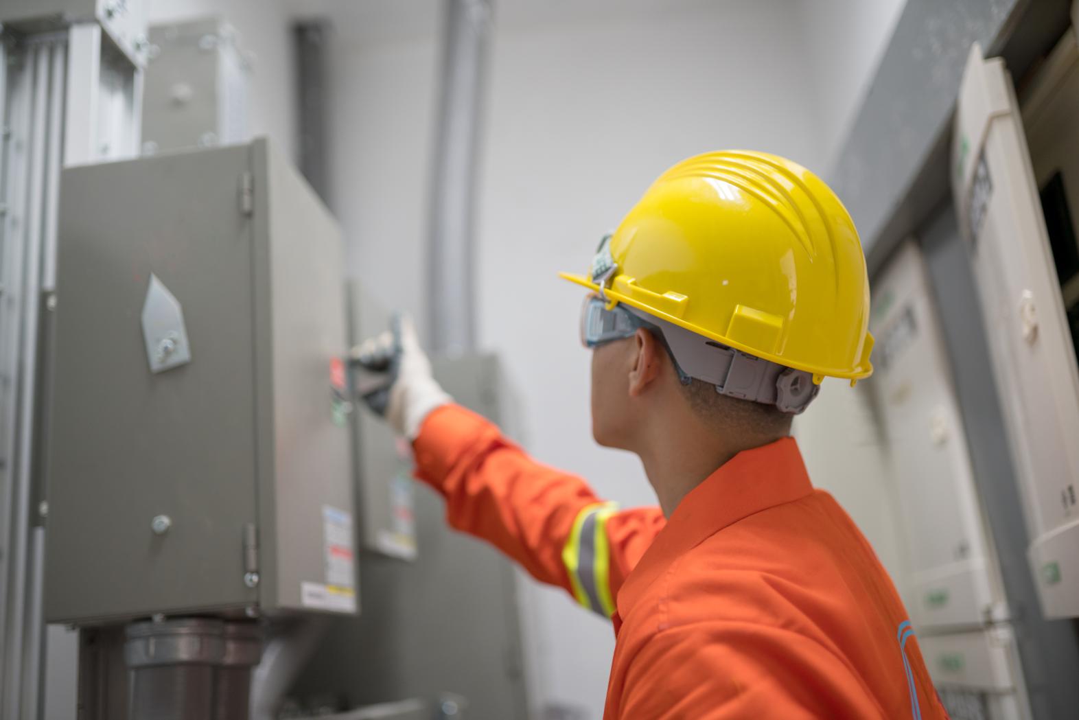 Technician reviews safety information on electrical panel