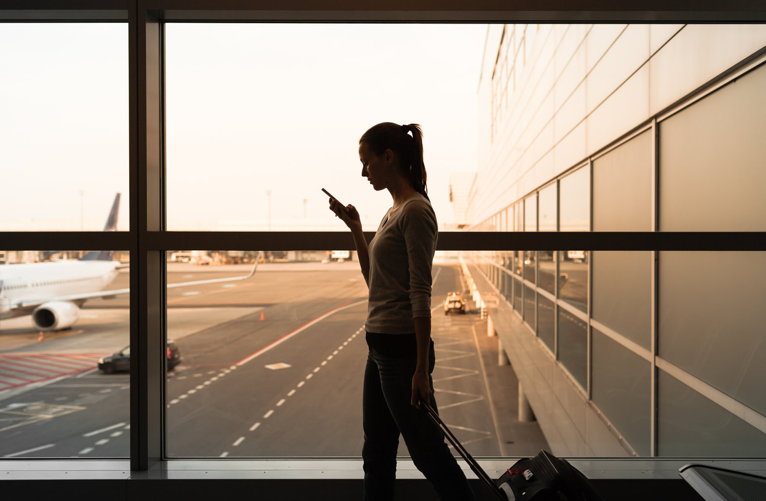 Woman traveling with phone and luggage