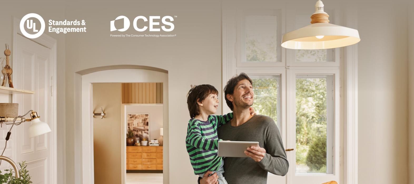 Father holding an ipad and son in a kitchen looking at ceiling light