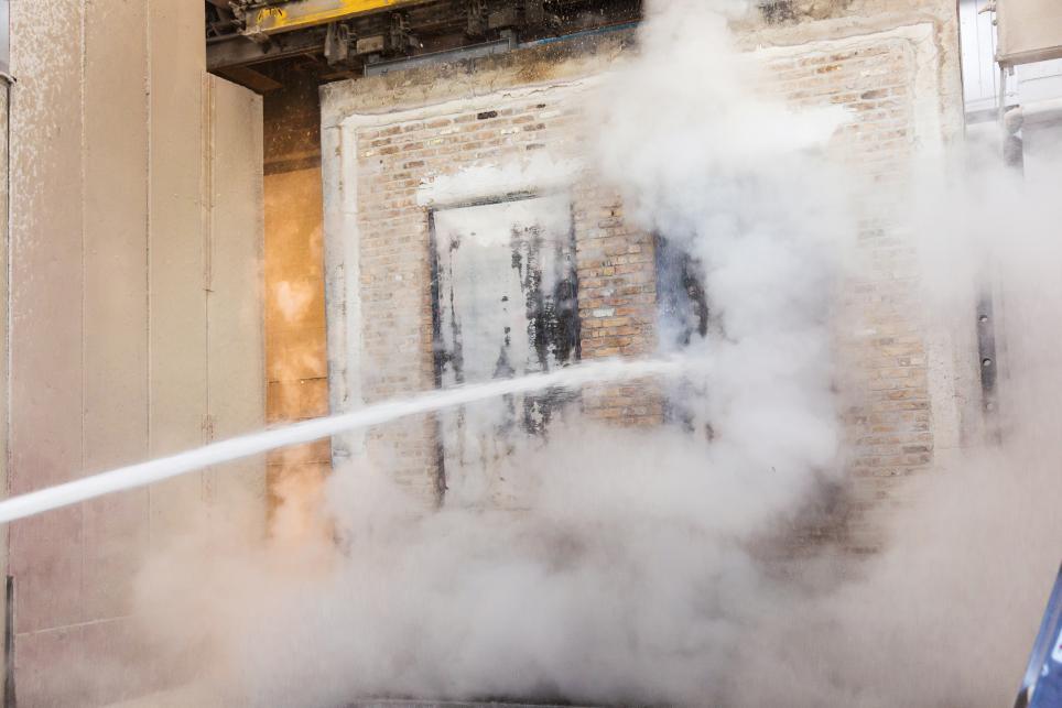 A Fire door being sprayed by a fire hose following fire exposure during a test outlined by UL 10B