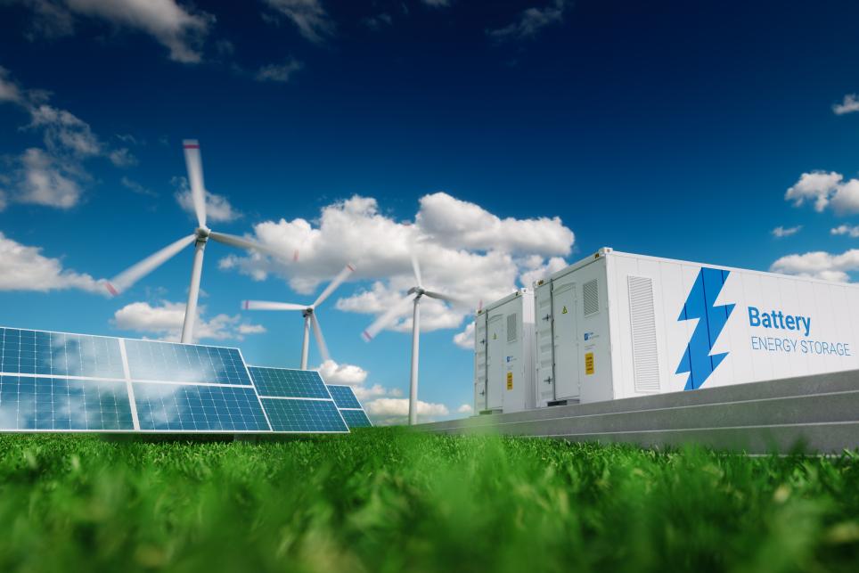 Battery Energy Storage System with Windmill and Solar Panels Outdoors. Battery systems storing energy from green power sources.