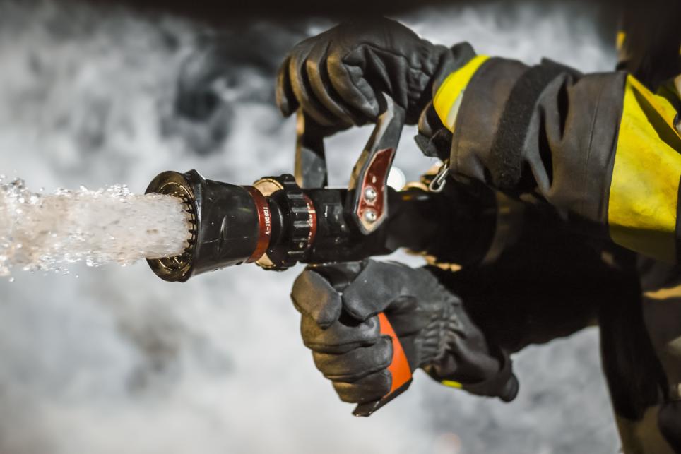 Firefighter attacking a fire with a fire hose
