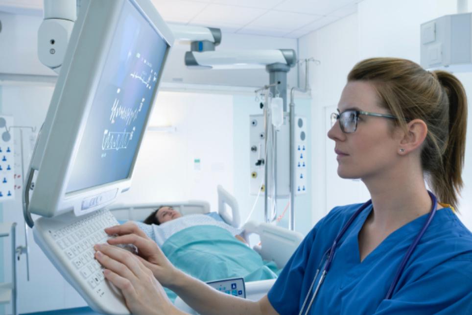 Woman in blue scrubs using medical device
