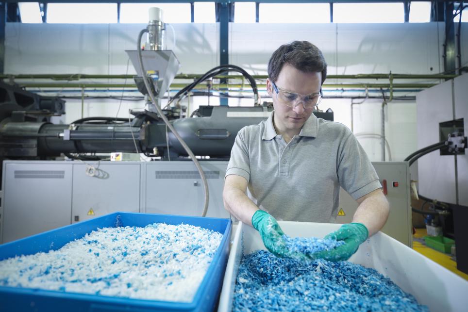 Worker sorting through recycled plastic.