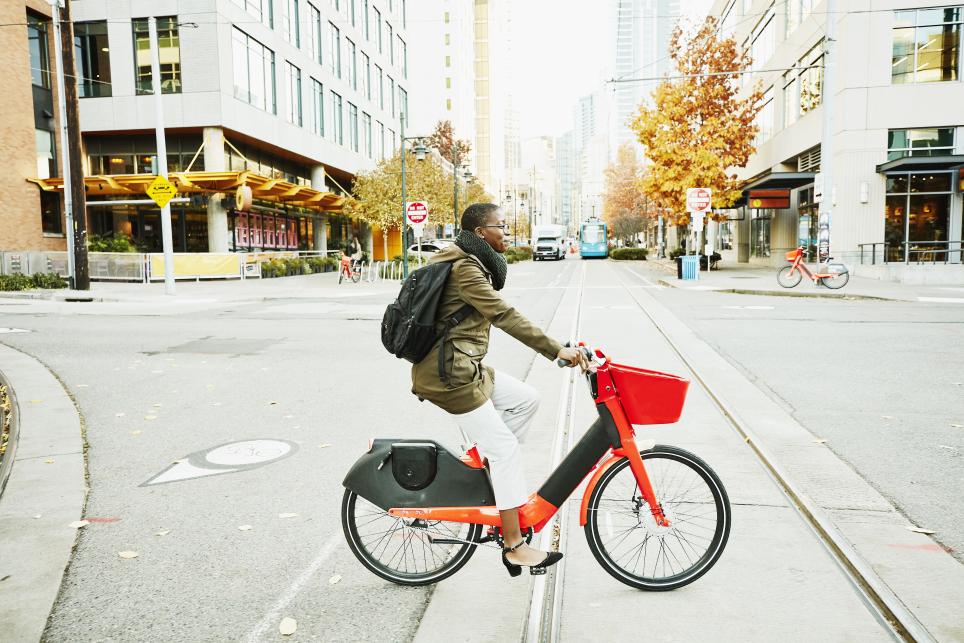 Woman crossing street with e-bike.