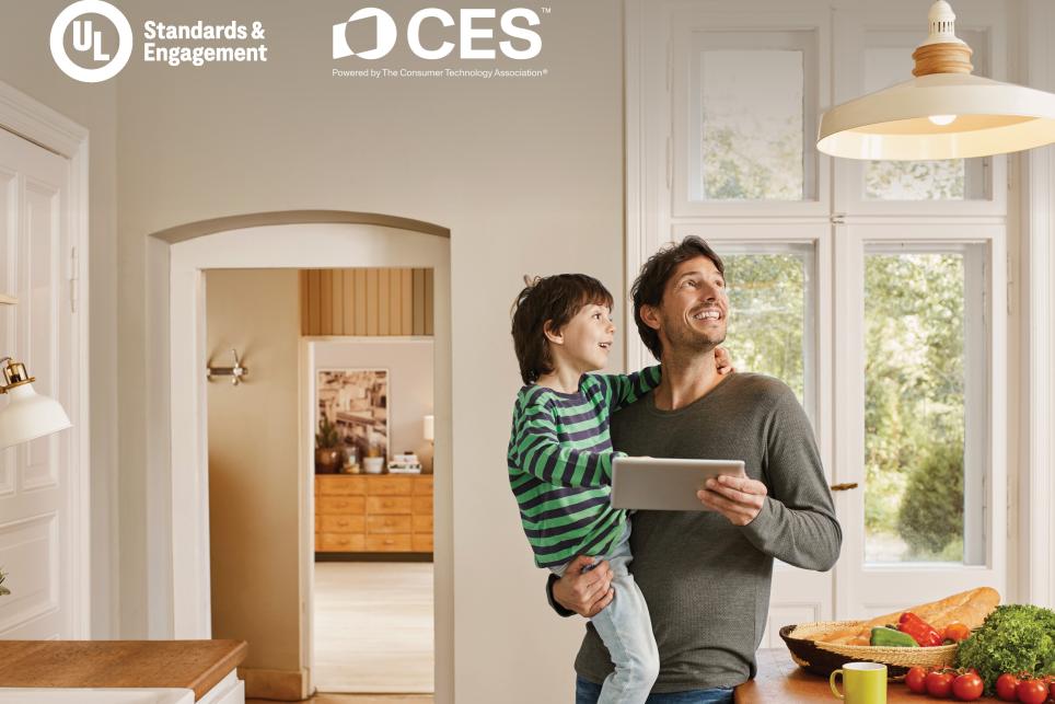 Father holding an ipad and son in a kitchen looking at ceiling light