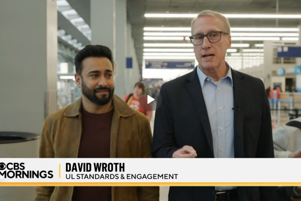 Two men have a discussion as they walk through an airport