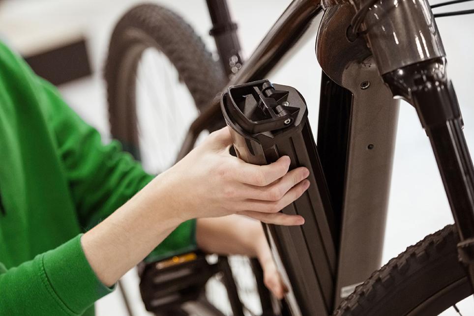 A woman changes her e-bike battery before going on a nice ride