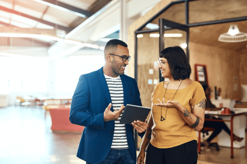 Man and woman talking in modern office hallway