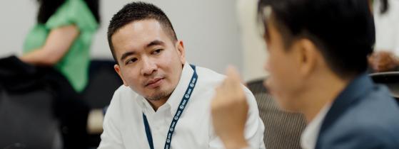 Two male colleagues speaking in meeting