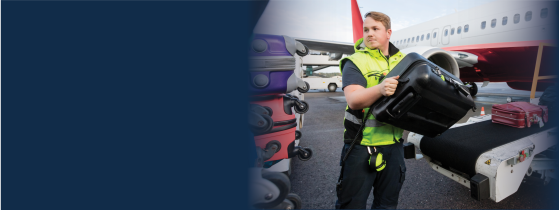 Ground support crewmember loads suitcases onto a plane 