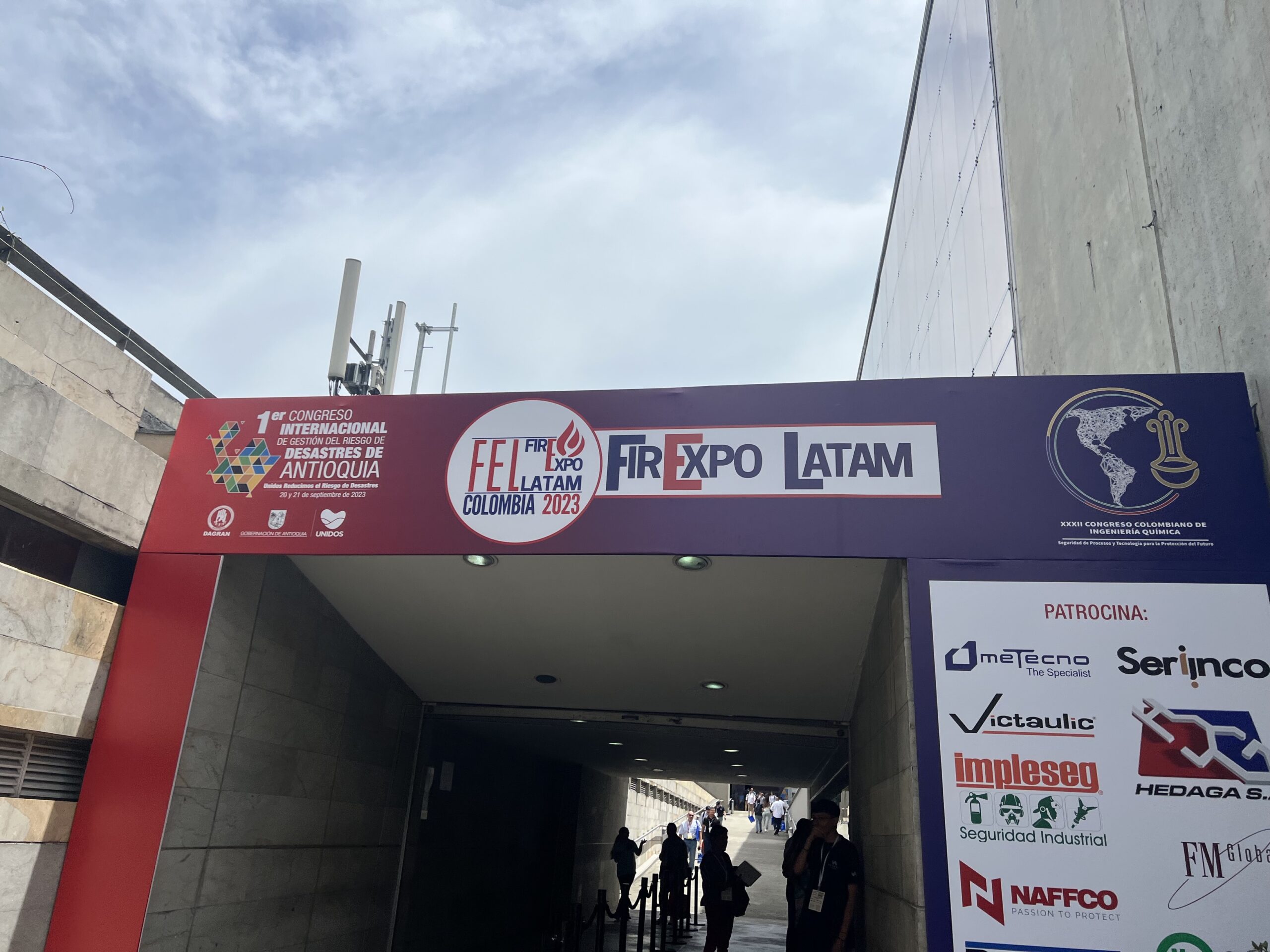 Entrance to an event with signs reading "FR Expo LATAM Colombia 2023" and "1er Congreso Internacional Desafíos del Sector de Antioquia." Logos of sponsors are displayed on the right side.