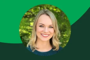 Portrait of a smiling woman with blonde hair, wearing a dark green top, in front of a leafy green background, framed by a circular graphic with green shapes.