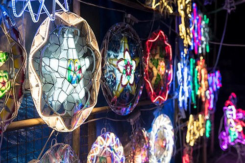 A group of colorful lanterns is on display for sale at a night market.