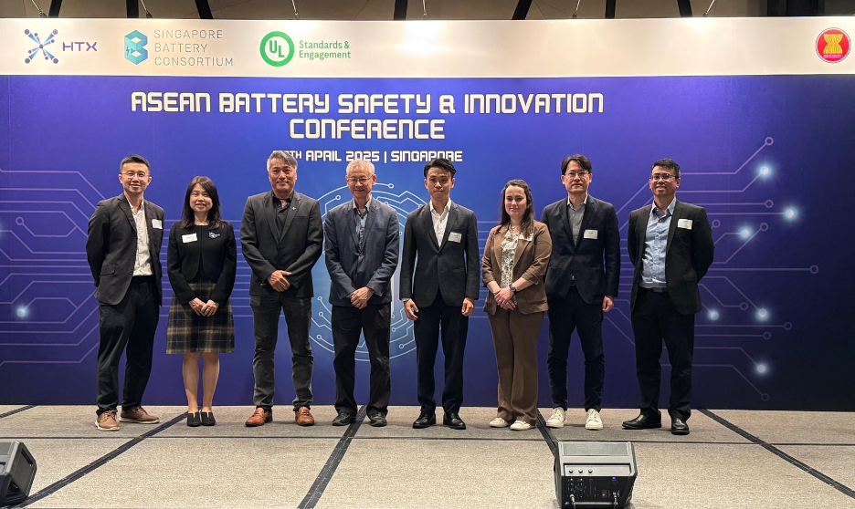 a group of individuals standing in front of a sign that says ASEAN Battery Safety & Innovation Conference