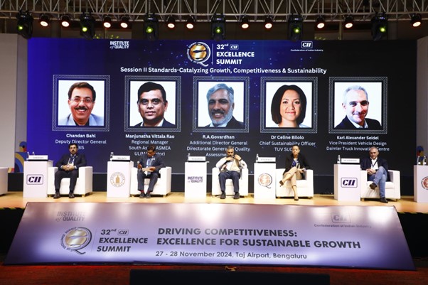 Five panelists sit on stage at the 32nd CII Excellence Summit in Bengaluru. A large screen behind displays their names, titles, and photos, with the summit's theme: "Excellence for Sustainable Growth.
