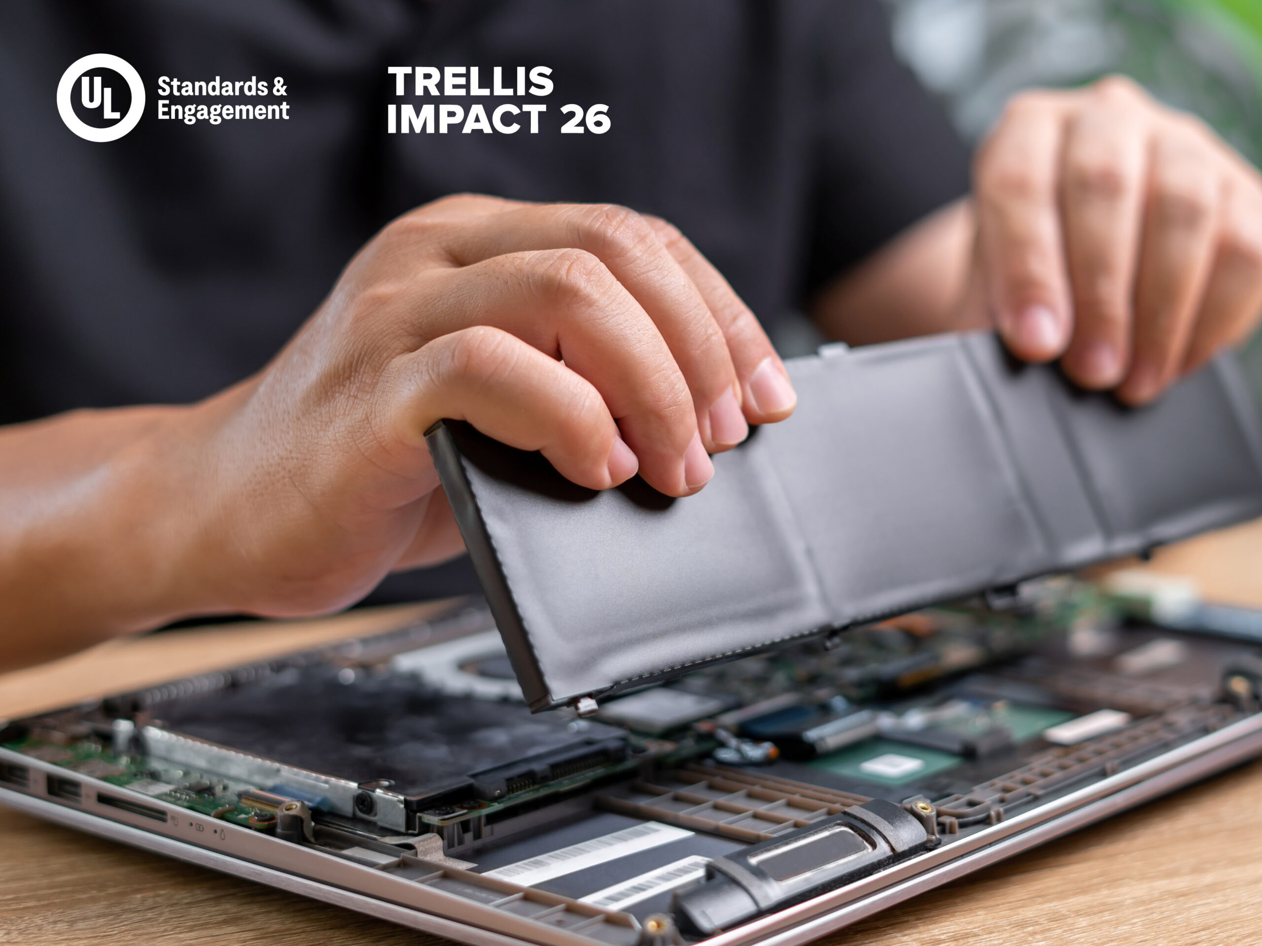 A person’s hands removing a laptop battery from an open device. Text in the top left corner reads: "UL Standards & Engagement" and "Trellis Impact 26.