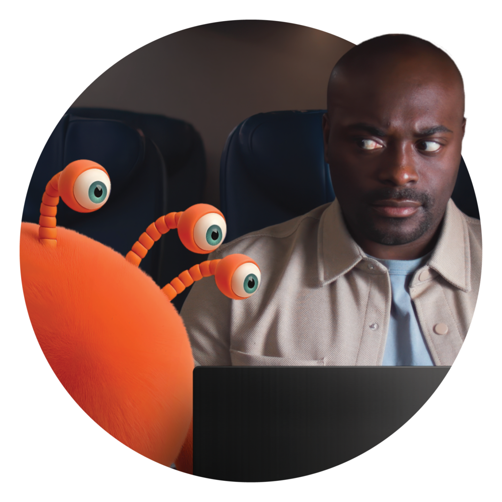 A man looks nervously at an orange, cartoonish creature with three eyes on stalks, sitting next to him on an airplane.